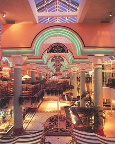 the inside of a shopping mall filled with lots of furniture and decorations, including benches