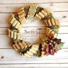 a wreath made out of wine corks on a white wooden background with the words true wine gifts written across it