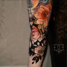 a woman's arm with flowers and a bird on it