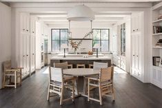 a dining room table and chairs in front of an island with built - in bookshelves