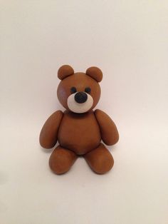 a brown teddy bear sitting on top of a white table