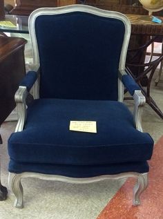 a blue chair sitting on top of a carpeted floor