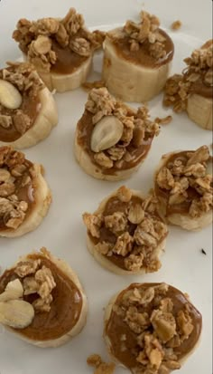 several desserts are arranged on a plate with nuts and peanut butter in the middle