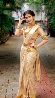 a woman in a gold sari posing for the camera