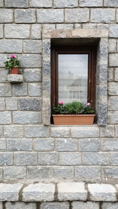 a brick wall with two flower boxes on the window sill