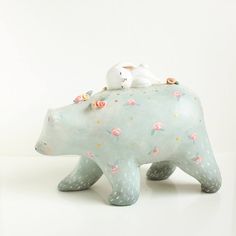 a ceramic polar bear figurine with two white birds on it's back