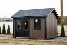 a small brown shed sitting on top of a grass covered field