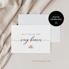 two wedding rings on top of a white envelope with the words, will you be our ring bearer?