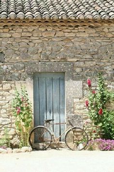 two bicycles parked in front of a stone building with flowers growing on the windowsill