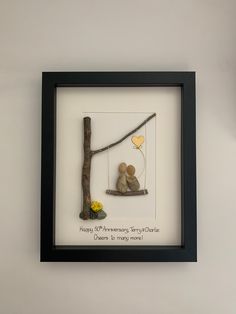 there is a framed picture of two mice on a swing