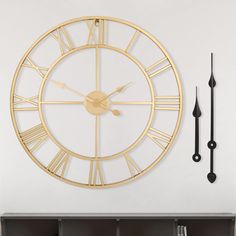 a large gold clock mounted to the side of a wall next to a book shelf