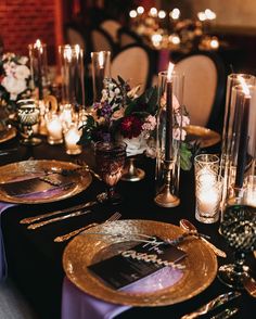 the table is set with candles, plates and place settings for an elegant dinner party