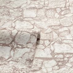 an old stone wall with a window in the middle and a cat sitting on it's side