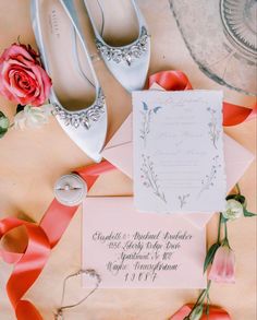 the wedding shoes are laying on top of the card and ribbon next to each other