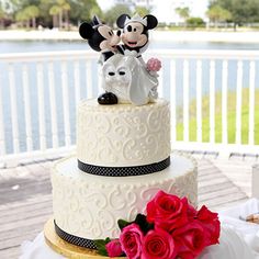 a wedding cake decorated with mickey and minnie mouse figurines