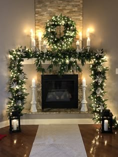 a fireplace decorated for christmas with candles and garland