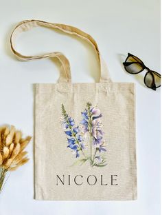 a tote bag sitting on top of a table next to a pair of glasses