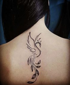 the back of a woman's neck with a bird tattoo on it