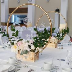 the table is set with white flowers and greenery