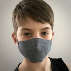 a young boy wearing a face mask to protect himself from the sun and cold weather