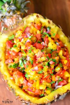 pineapple salsa in a pineapple bowl on a wooden table