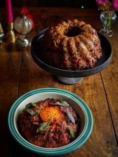 a bundt cake sitting on top of a table next to a bowl of food