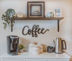 there is a coffee sign on the wall next to some cups and other items in front of it