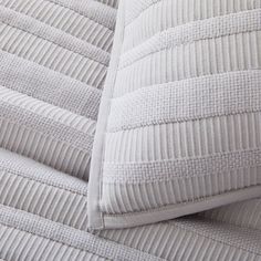 a close up view of the back end of a white couch cushion with pinstripe pattern