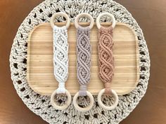 three crocheted objects are on a wooden tray with scissors and yarn around them