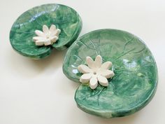 two green plates with white flowers on them