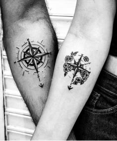 two people with tattoos on their arms holding each other's hands and looking at the same direction