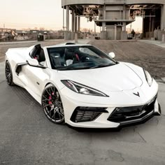 a white sports car parked in front of a building