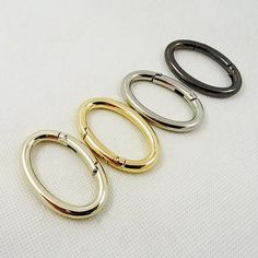 three different colored metal rings on a white surface