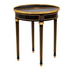 a black and gold side table with an oval glass top on one leg, two small legs