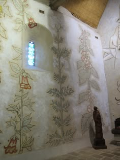 an artisticly painted wall in a church with a stained glass window on the side