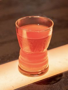 a glass filled with liquid sitting on top of a counter