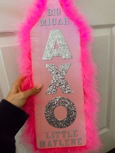 a pink door hanger with glitter letters on it