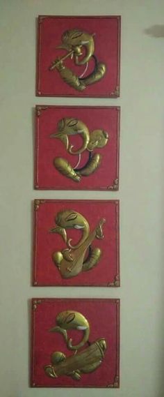 three red and gold paintings hanging on the wall