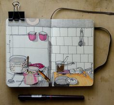 an open notebook with a drawing of pots and pans on the kitchen counter next to a pen