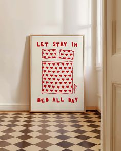 a red and white poster sitting on top of a checkered floor next to a window