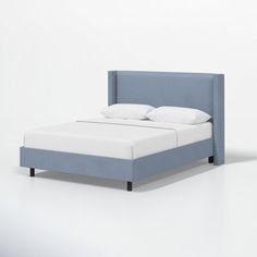 a bed with white pillows and blue headboard on top of it, against a white background