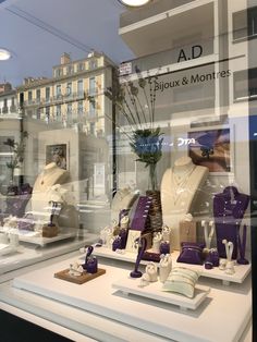 a store window with mannequins and jewelry on display