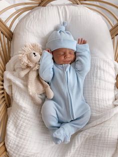 a baby is sleeping in a wicker basket with a stuffed animal next to it