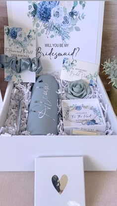 a white box with blue flowers and cards in it that says will you be my bridesmaid?