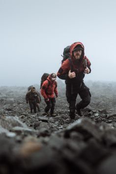 a group of people hiking up a mountain in the fog