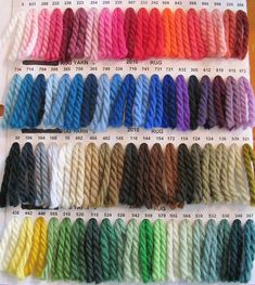 there are many different colors of yarn on the table