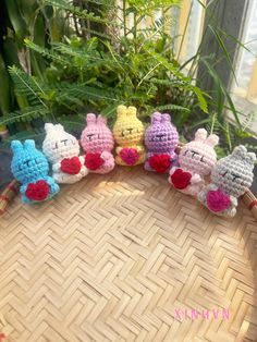 small crocheted stuffed animals sitting on top of a wicker basket next to plants