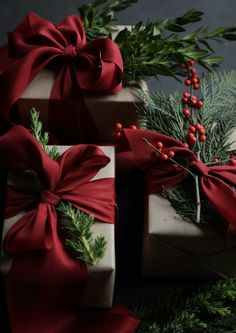 presents wrapped in red ribbon with holly and berries on them, sitting next to each other