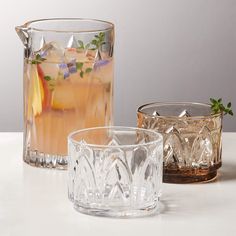 three glasses filled with drinks sitting on top of a white counter next to each other