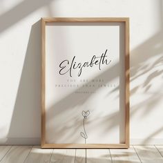 a wooden frame on the floor with a plant in front of it that says ellygateth